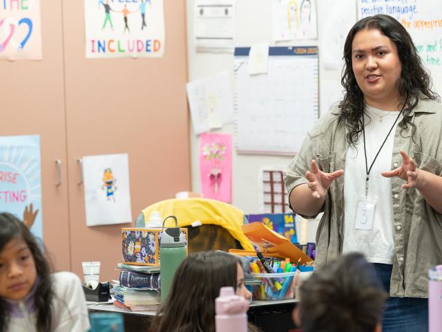 College student stands in front of a class at an elementary school