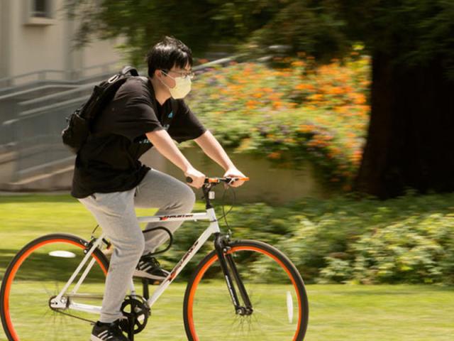 student rides her bike near uc davis memorial union