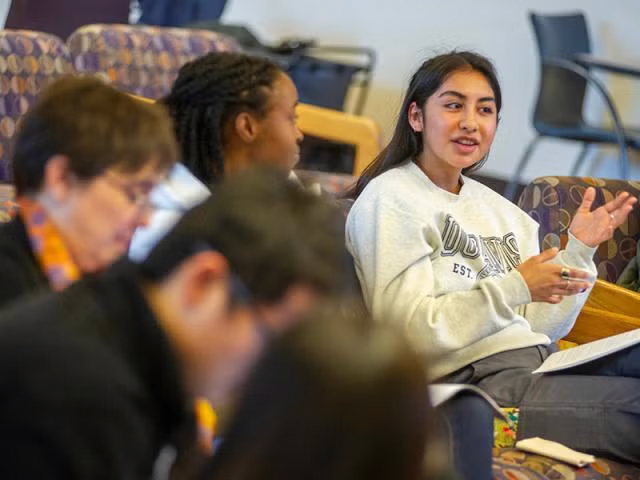 A student talking in a classroom of students