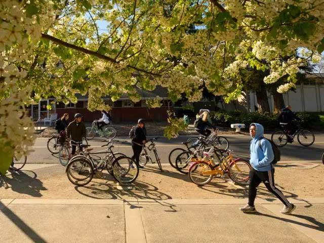 Student walking in front of the Memorial Union next to some bikes
