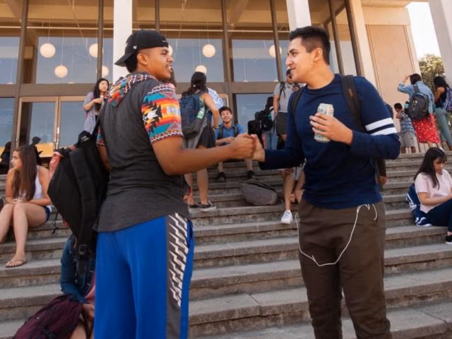 Two students embracing in a handshake