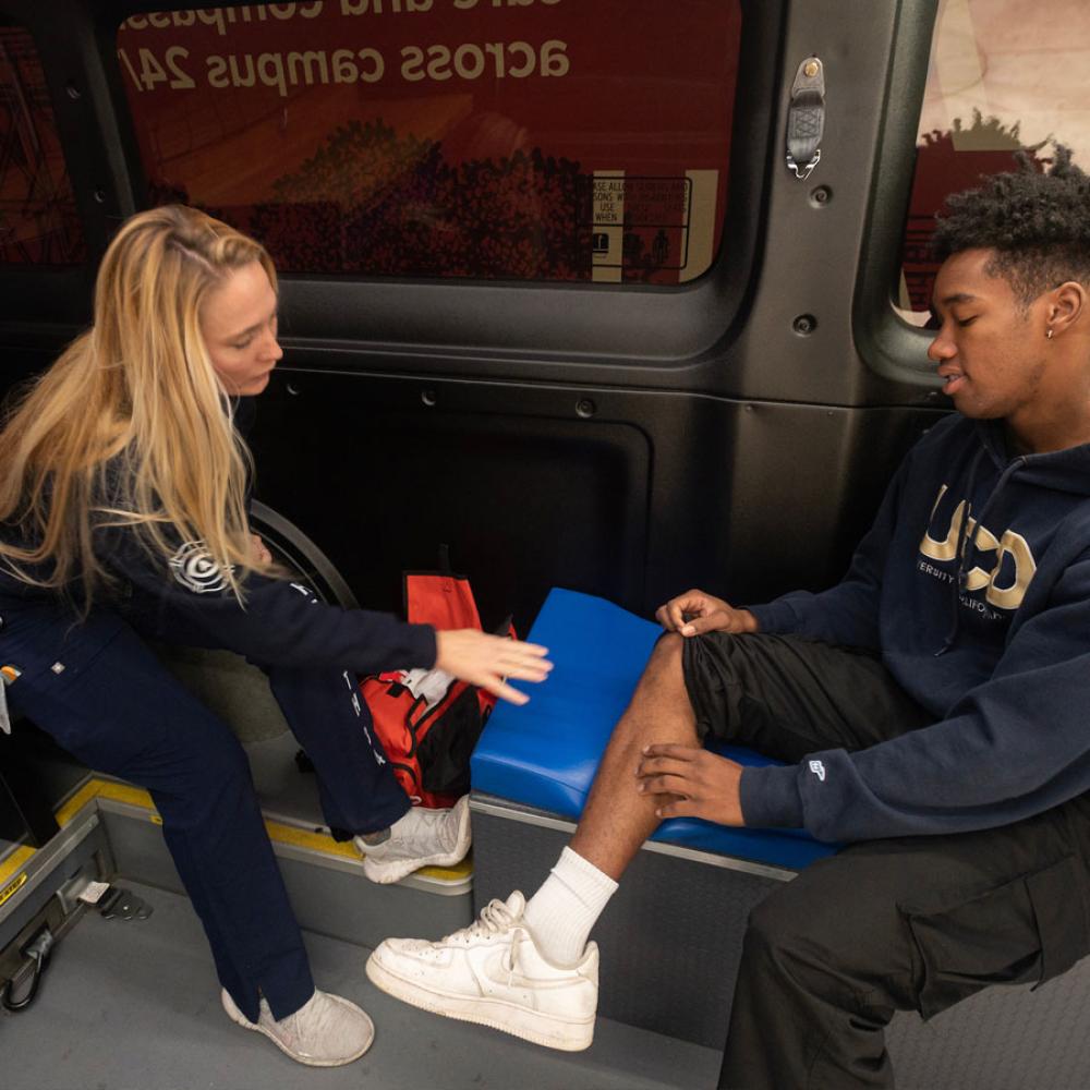 A health 34 first responder helps a student with an injured leg