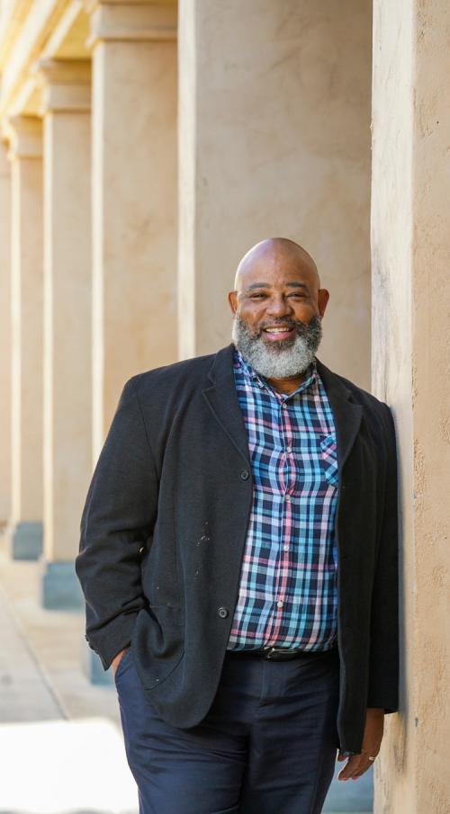 Milmon Harrison, standing against wall, exterior, Hart Hall