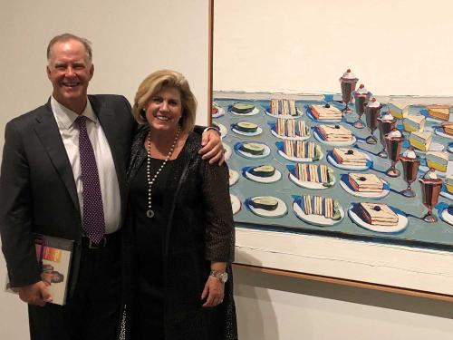 Couple standing in front of painting at museum.