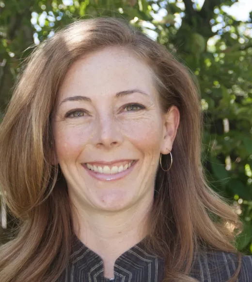 head shot of Stephanie Hampton smiling with trees in backdrop