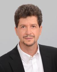 A portrait of Andrés Reséndez with a gray background.