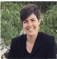 portrait of woman wearing black in front of greenery