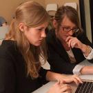 Two women studying a screen on a laptop