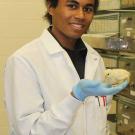 Man in white coat holding a chicken