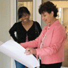 Cynthia  Picket, left, an associate professor of psychology and mother of a 2-year-old daughter, looks at planning documents for the center with regional manager Karen Valech.