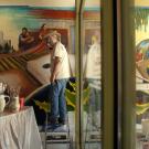 Photo: Professor Emeritus Malaquias Montoya, at work on "The Practice of Freedom" mural