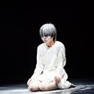 Person kneeling on floor, covered in white powder