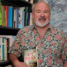 Nigel Allan is shown in his office, surrounded by textbooks and a topographical map of Afghanistan.