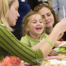 Noah Vinokurov works on a mask-decorating project with assistance from Jaime Reed, left. Also pictured is Noah's mother, Michal Kurlaender.