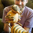 Radomir Schmidt holds a ceramic wasp, about 20 inches tall.