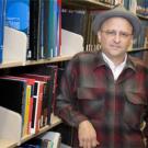 Photo: man in hat in library stacks