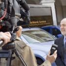 photo: man being interviewed by television reporter with camera behind