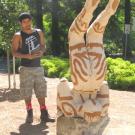 Photo: Bryan Ramirez-Corona views his untitled "green" sculpture in the outdoor exhibition.