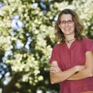 Emily Griswold stands amid the magnificent trees of the Shields Oak Grove.