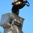 After putting a new lamp in a streetlight on Hutchison Drive, campus electrician Rick Noring works on repairing the fixture -- which he ends up replac