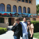 Chicana/o studies and art professor Malaquias Montoya, left,  painted this mural on the outside of the El Centro Chicano building at Stanford in 1981. He is pictured with his wife, Lezlie Salkowitz-Montoya, right, and son Maceo, an artist as wel