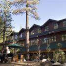 Photo: Front of a two-storied building with trees, rocks and people in front