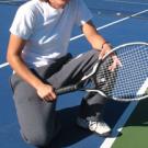 Sara Morenc '01, assistant coach for the Aggie women's tennis team, shows a ball that is in -- because at least part of the ball is touching the line.
