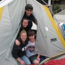 Students Chris Perry, Courtney King, Jamie Flynn and Adam Darbonne peek out of a tent outside the Pavilion.