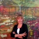 Marie Thibeault stands in front of Arena (oil on canvas, 71 by 77 inches), a 2007 work inspired by Hurricane Katrina