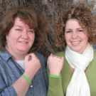 Paula Driver Shimada, left, and Brooklynn Mundy of the WorkLife unit show off the &lsquo;alien green&rsquo; wristbands that children will wear for Take Our Daughters and Sons to Work Day.