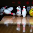 Bowling pins being hit by a bowling ball.