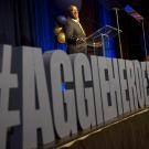 Chancellor Gary S. May speaks with a sign in front of him that reads #AggieHeroes.