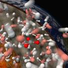 Model of various colored molecules as they dissolve with a cross section of the Earth behind