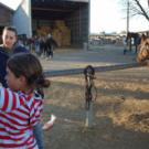 The Equestrian Center is slated to move from its 27-acres south of the Veterinary Medical Teaching Hospital to a site twice that size near Russell Ranch. Here, UC Davis student Mara Veneman, who works at the center, looks on as local youths &mdash; 