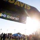 An arch with a sign that reads "welcome to UC Davis."