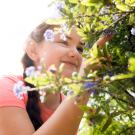 Young girl looks at a plant.