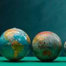 Five different-sized globes of the world.