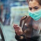 Masked woman looks at empty food display in grocery store