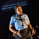 Opera actor in police uniform, singing.