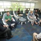 Visitors and international students and scholars sit in a semicircle.