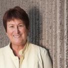 Judith A. Kjelstrom, environmental, standing against concrete wall