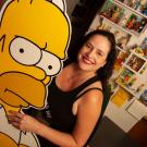 Karma Waltonen poses with larger-than-life-size cardboard cutout of cartoon character Homer Simpson.