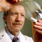 Photo: man in white coat looking at big bubble