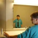 Photo: woman going to touch light switch in bathroom