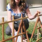Photo: Margaret Lloyd kneeling next to a garden.