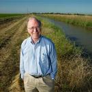 Man standing alongside a canal in the wetlands