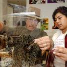Photo: Man and woman examine silk-screen transparency.
