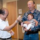 Geologist showing meteorite to baby and donor Gregory Jorgensen.