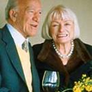 Photo: man holding wine glass next to woman with flowers