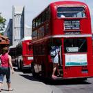 photo: woman walking toward double-decker bus